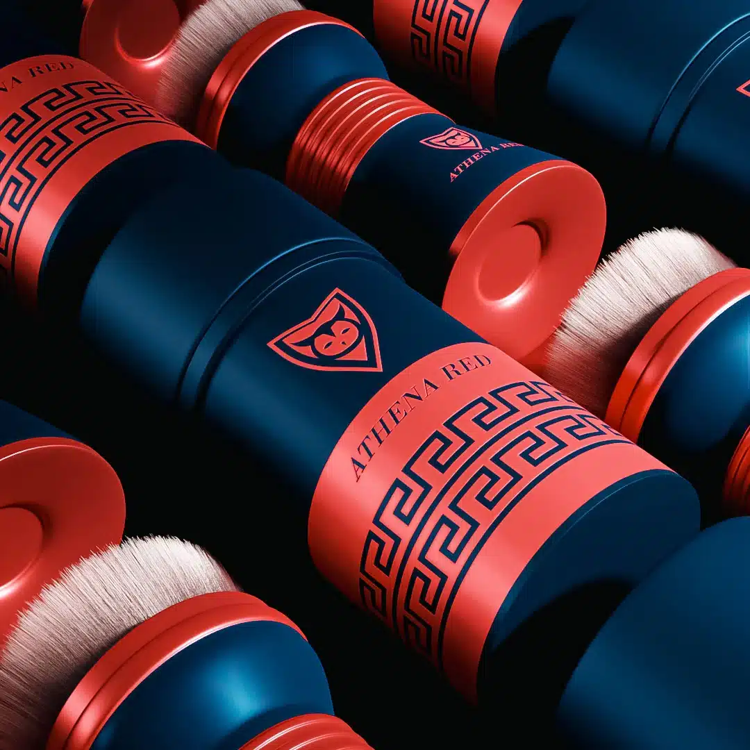 athena-red-makeup-brushes-close-up Rows of navy makeup brushes with red Greek key bands and Athena Red logos.