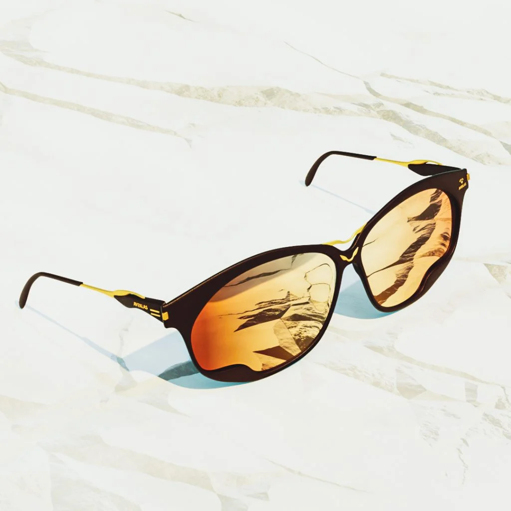 sunglasses-on-white-marble-surface Dark sunglasses with gold arms resting on a pale white marble surface