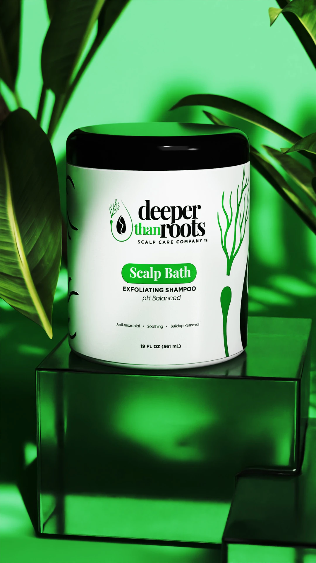 deeper-than-roots-scalp-bath-jar Deeper Than Roots Scalp Bath jar sitting on a glass block among green leaves.