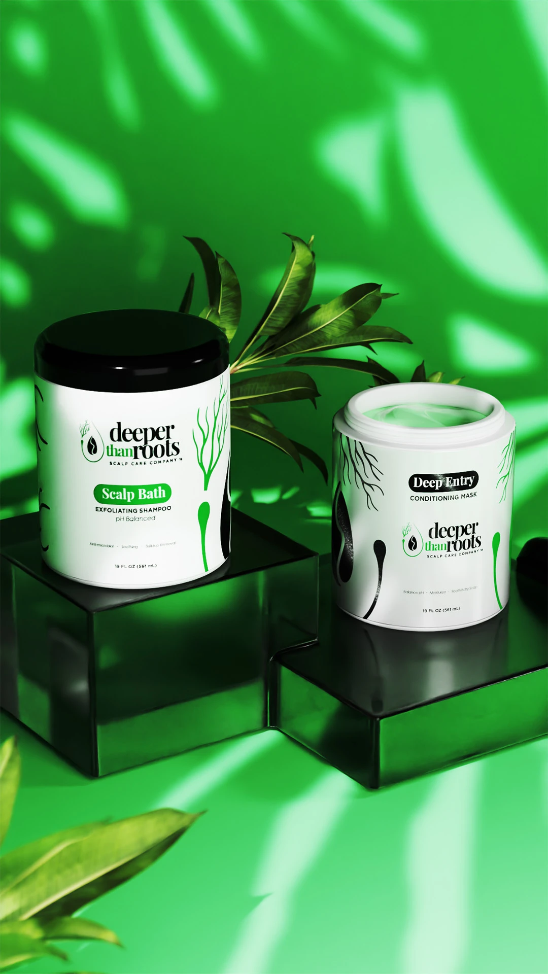 deeper-than-roots-scalp-care-jars Two Deeper Than Roots scalp care jars displayed on pedestals among green leaves.