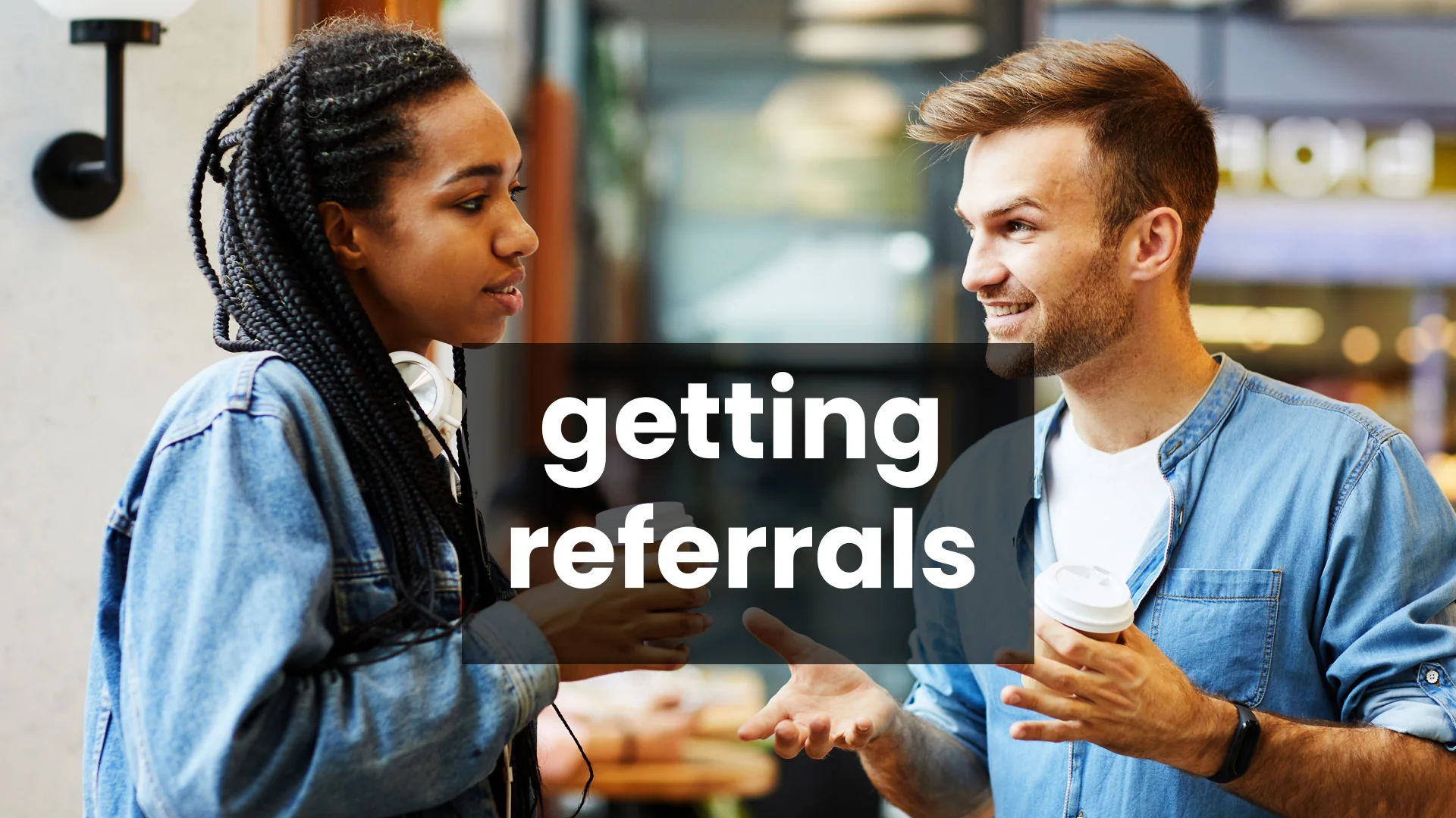 Getting Referrals Through Everyday Conversation A woman in a denim jacket and a smiling man hold coffee cups while chatting about getting referrals.