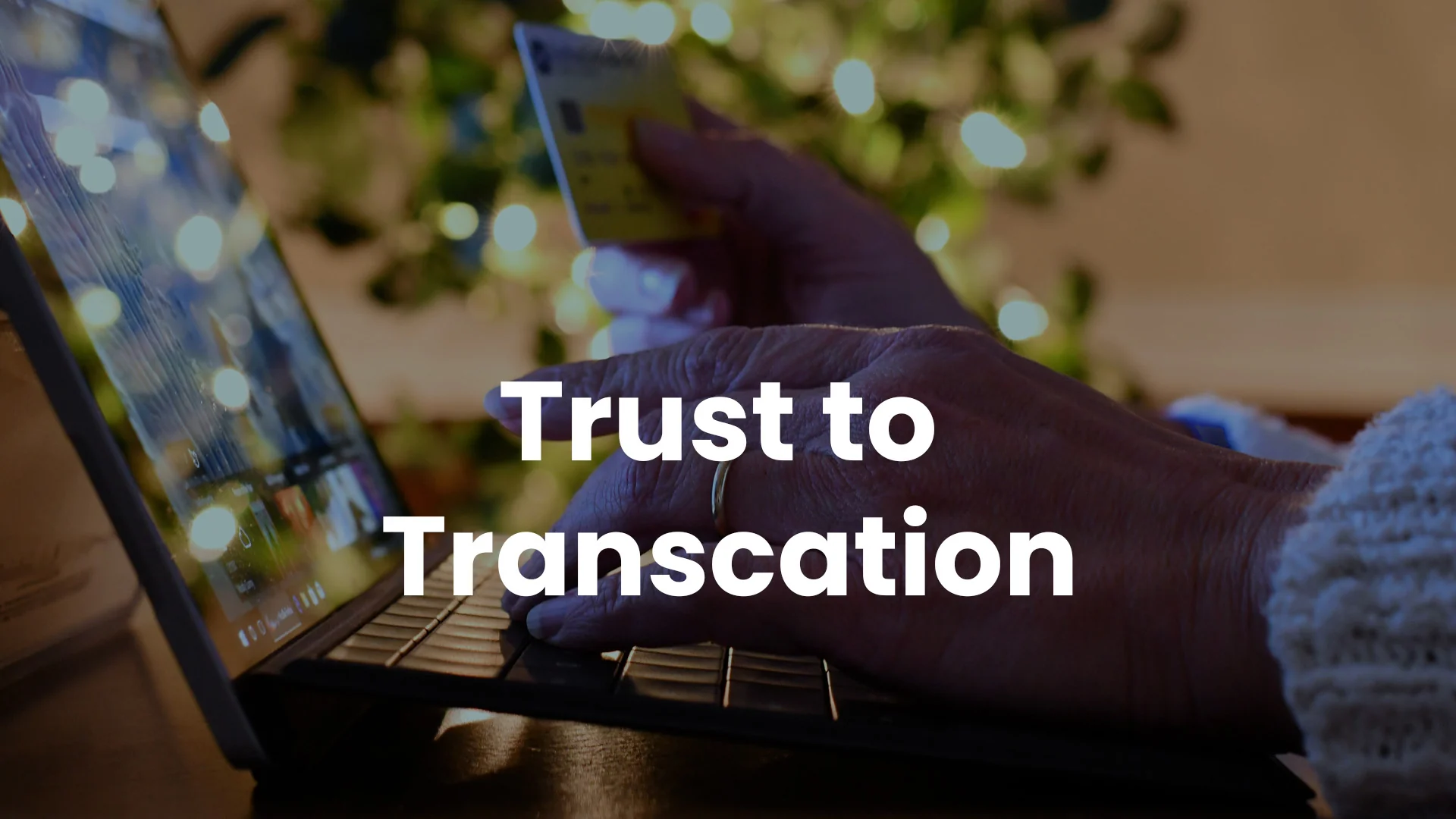 Trust to Transaction Hands hold a credit card over a laptop keyboard, with soft bokeh lights behind, during an online purchase.