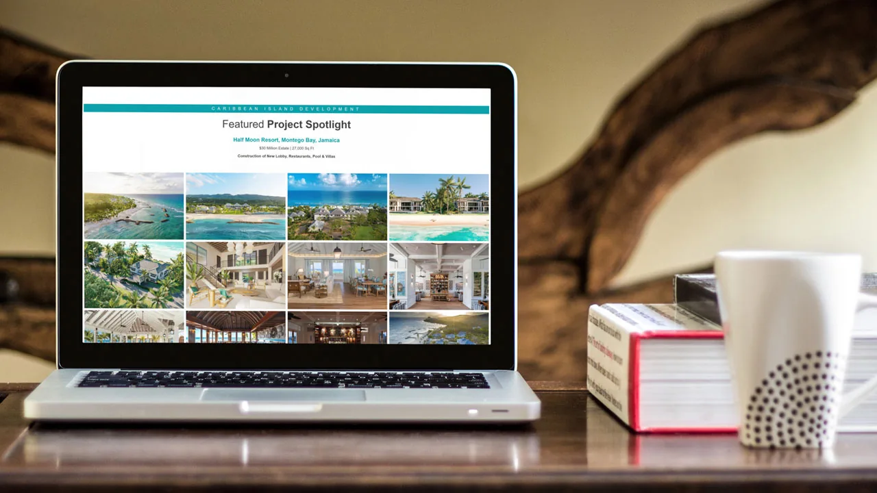 resort-project-gallery-website-design-laptop Laptop on a wooden desk beside a book and mug, showing a resort photo grid website design.